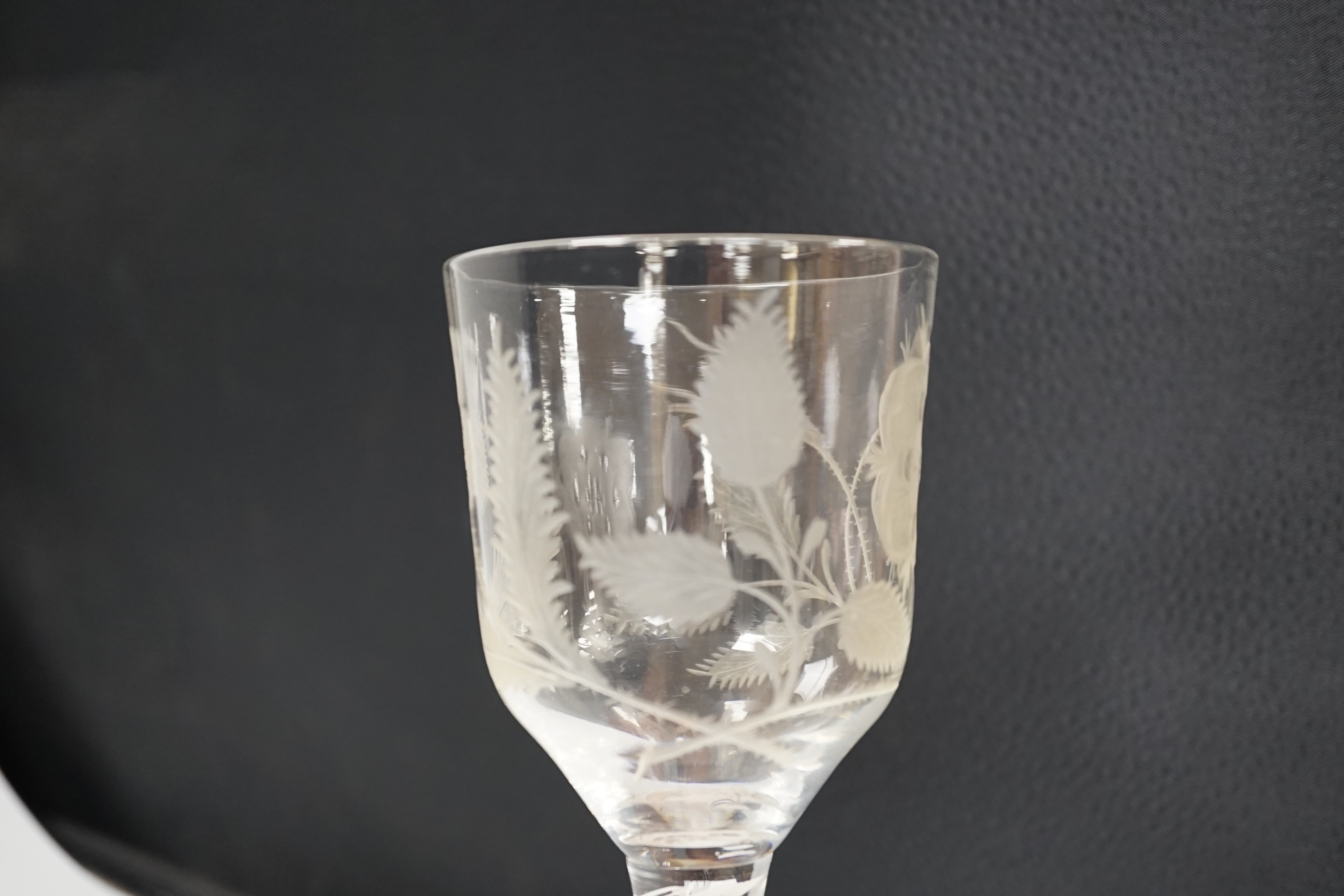 An English lead crystal Jacobite goblet, c.1750-60, bowl of ogee form, engraved with open and one closed rose and thistle, DSOT stem and plain foot with rough pontil, central gauze and multi spiral threads, tool marked,